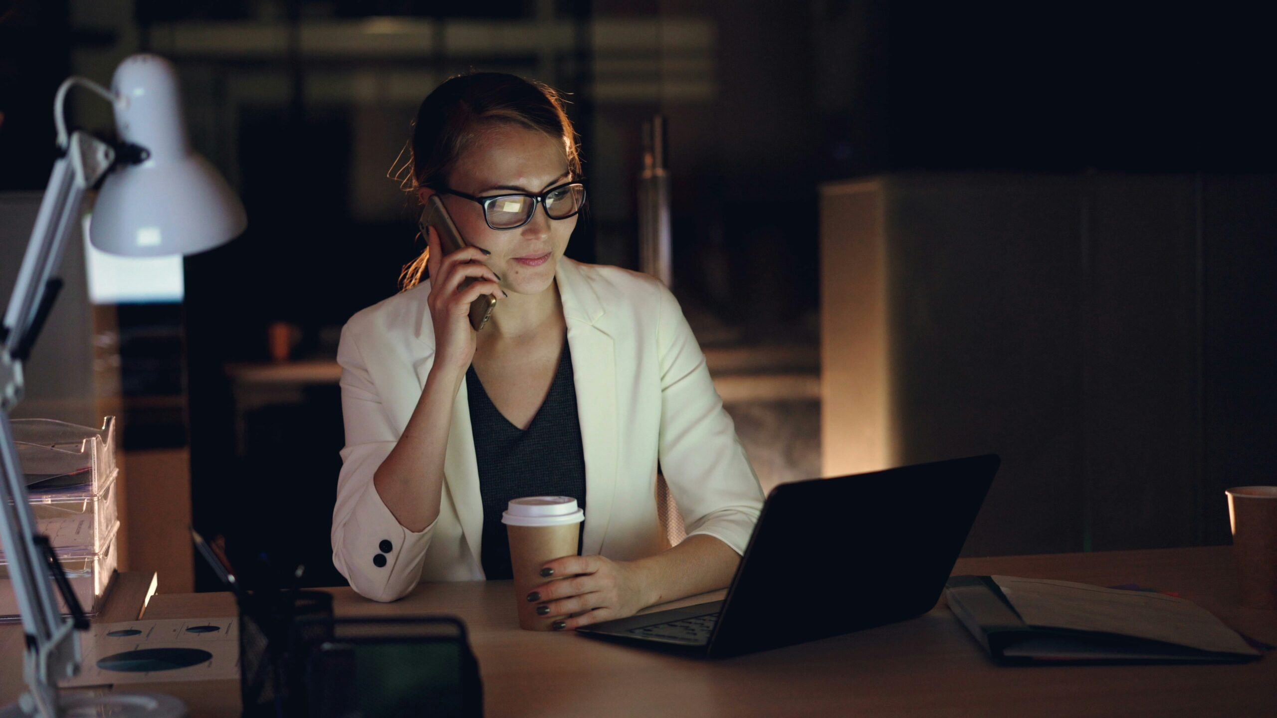 Small business owner looking thoughtfully at a laptop with warm natural light, representing a strategic pause